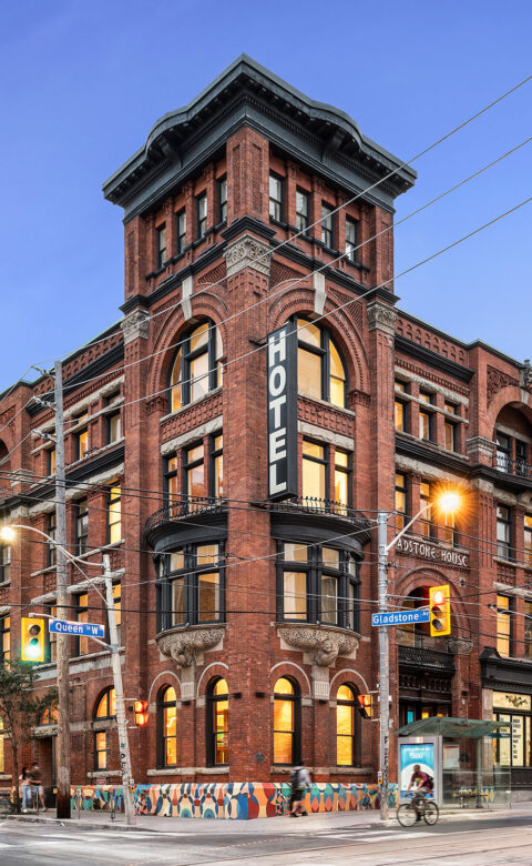 brick hotel building on the corner of a busy downtown street