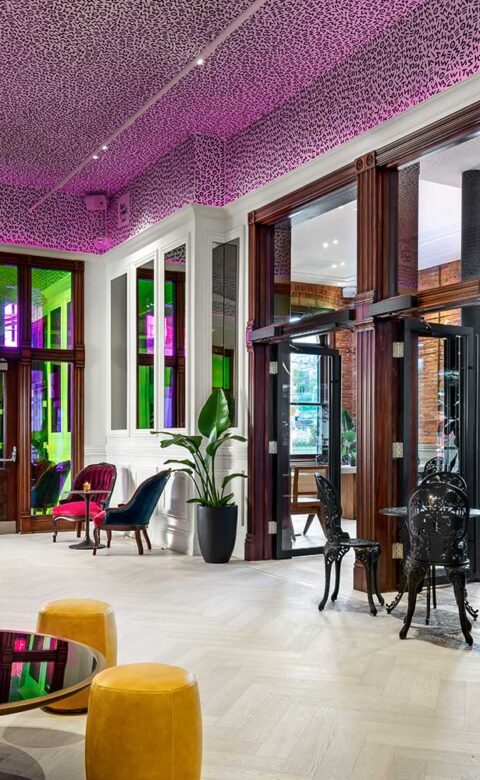 rendering of a cafe with a wooden bar, small tables, and brick interior wall