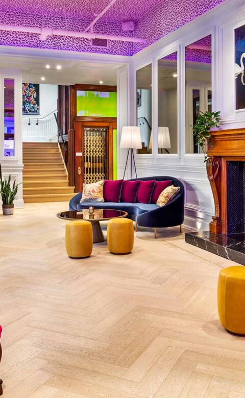 Gladstone House lobby with graphic painted ceiling and mid century modern furniture