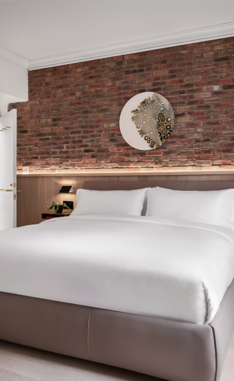 king size bed against a brick wall