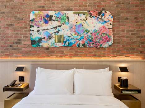 a bed with white sheets and pillows in a room